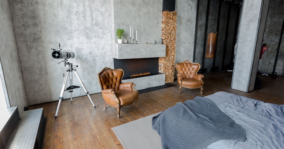 Schlafzimmer mit Kamin und Wand im Betonlook 