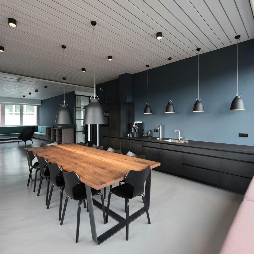 Pausenraum mit schwarzer Küche und langem Tisch