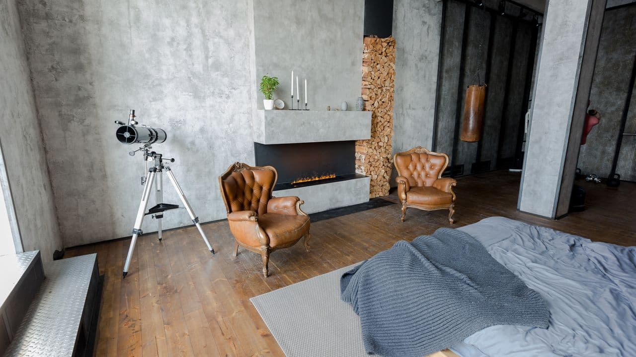 Schlafzimmer mit Kamin und Wand im Betonlook