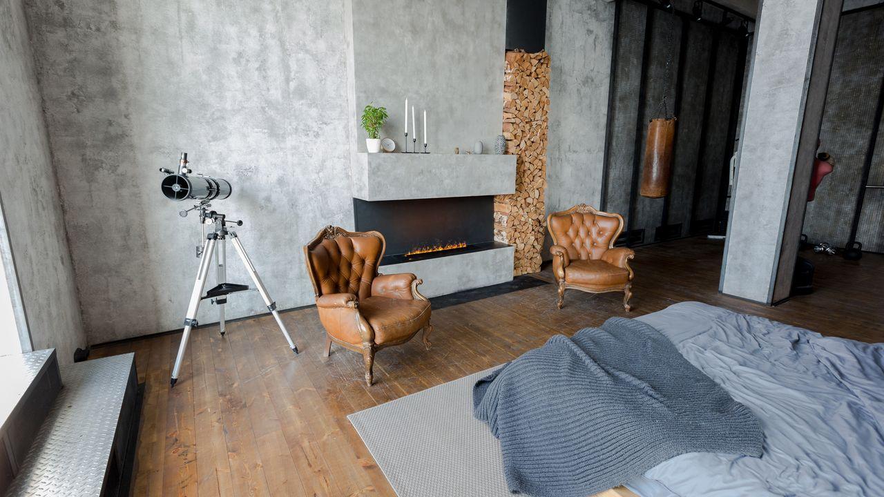 Schlafzimmer mit Kamin und Wand im Betonlook